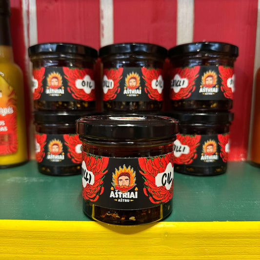 Aštrus traškus aliejus stiklainyje su raudonais žiedais, stovintis ant lentynos. Puikus azijietiško skonio pasirinkimas.