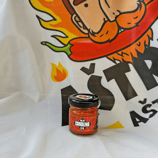 Nr. 24 Carolina MINI hot sauce jar on a flame-themed background, showcasing its intense flavor and heat.